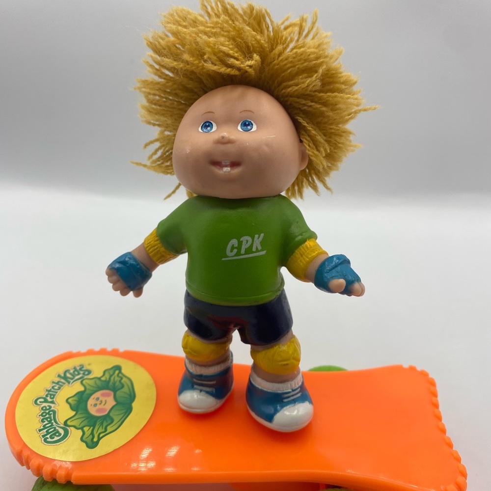 Vintage Cabbage Patch Kids Rolling boy on orange skateboard.